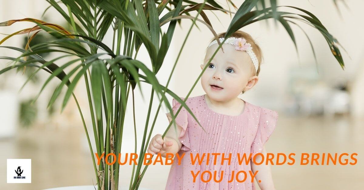 A baby girl touches a small plant to commiunicate