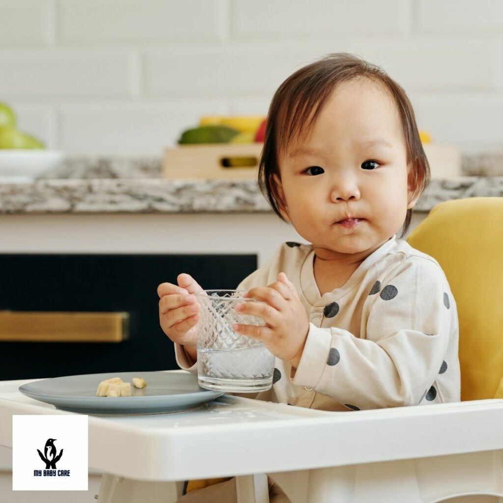 a baby is drinking from an open cup