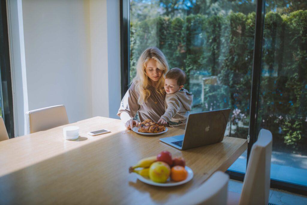  mom is feeding her beautiful baby on a table
