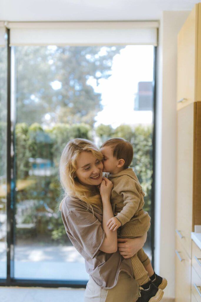 Baby is kissing mom's face