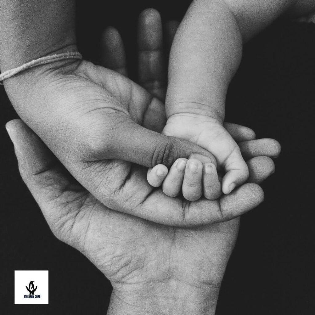 Mom and dad is holding little baby's hand