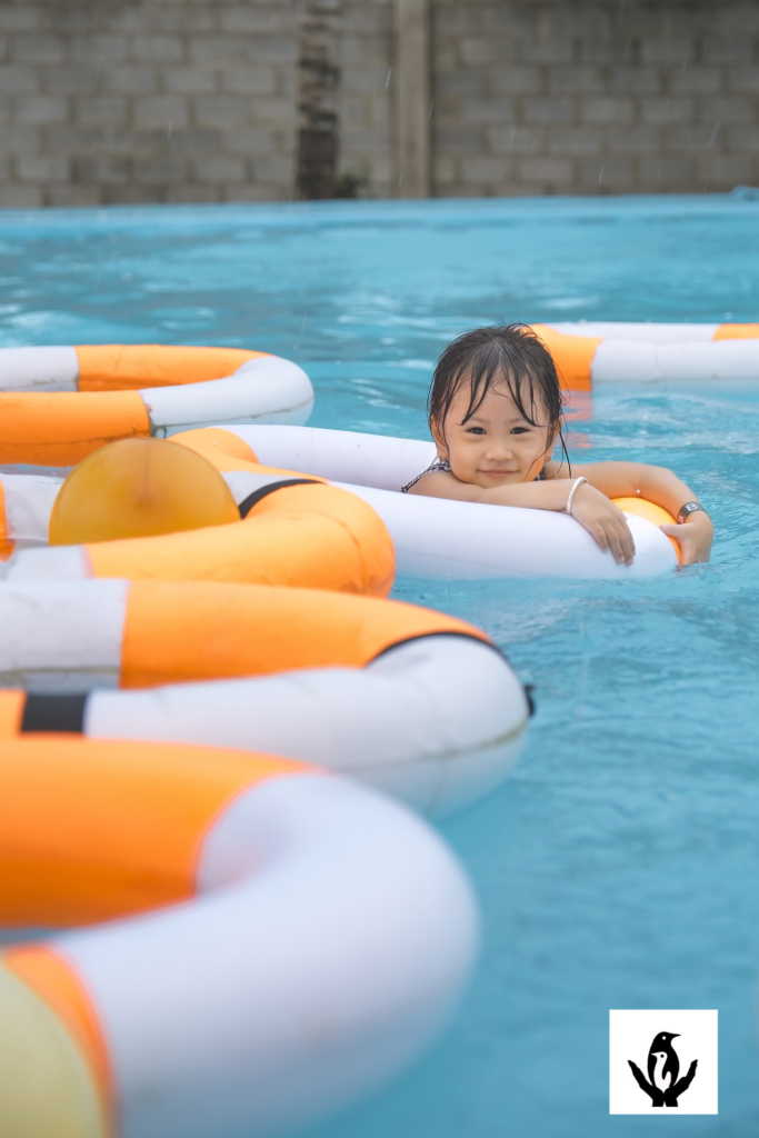 cute baby girl swims in the pool